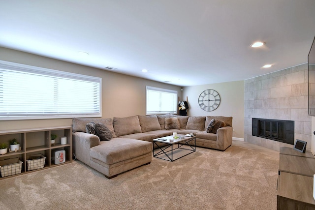 carpeted living area with visible vents, recessed lighting, and a tiled fireplace