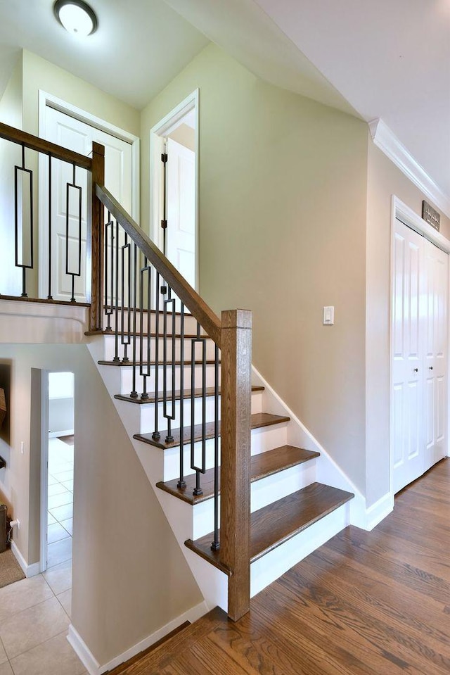 stairway with baseboards and tile patterned floors