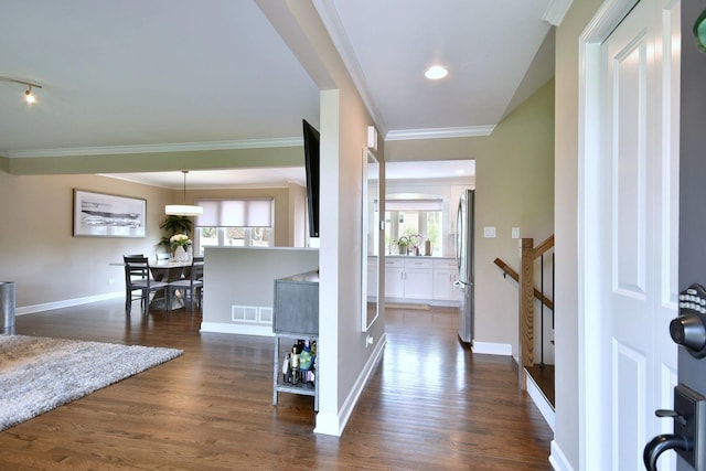 entrance foyer with crown molding, dark wood-style floors, and a wealth of natural light