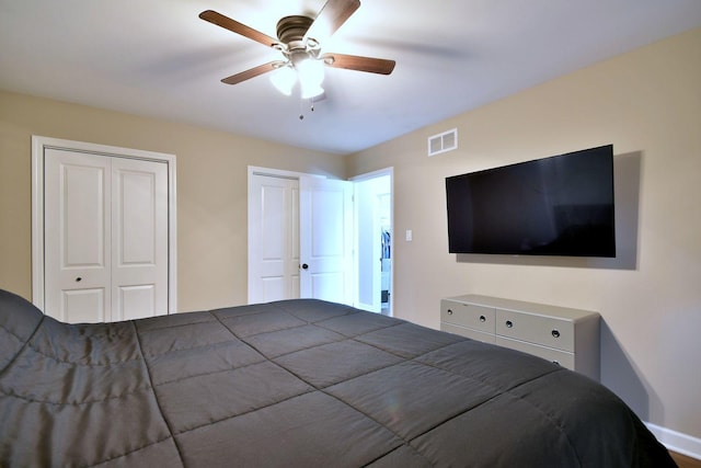 bedroom featuring visible vents, ceiling fan, and two closets