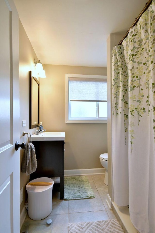 full bathroom with tile patterned flooring, curtained shower, vanity, baseboards, and toilet