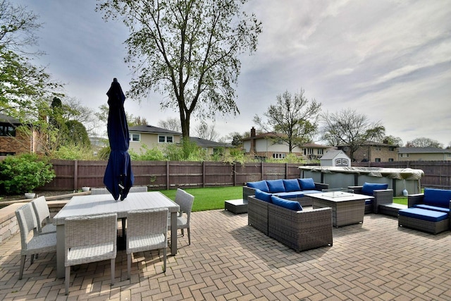 view of patio / terrace featuring outdoor dining area, a fenced backyard, outdoor lounge area, and a residential view