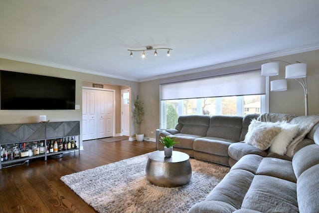 living area featuring a bar, baseboards, ornamental molding, and wood finished floors