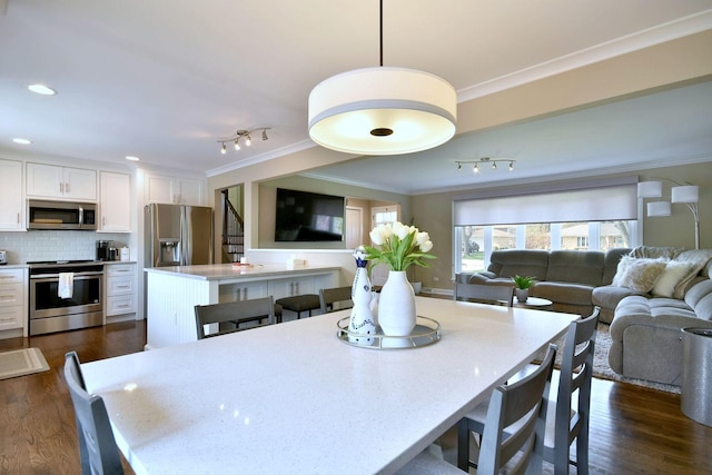 dining room with crown molding, recessed lighting, dark wood finished floors, and track lighting