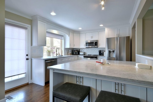 kitchen featuring a sink, decorative backsplash, white cabinets, and stainless steel appliances