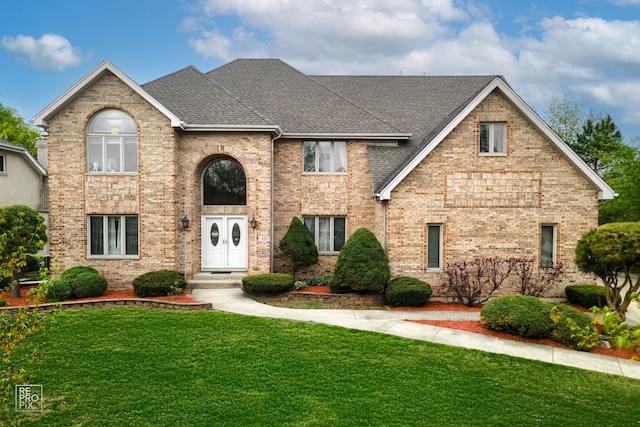 401 Jason Ln, Schaumburg, IL 60173 - traditional home featuring roof with shingles, a front lawn, and brick siding