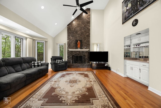 401 Jason Ln, Schaumburg, IL 60173 - living room featuring high vaulted ceiling, plenty of natural light, a stone fireplace, and light wood-type flooring