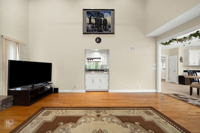 401 Jason Ln, Schaumburg, IL 60173 - living area featuring light wood-style floors, a high ceiling, and visible vents