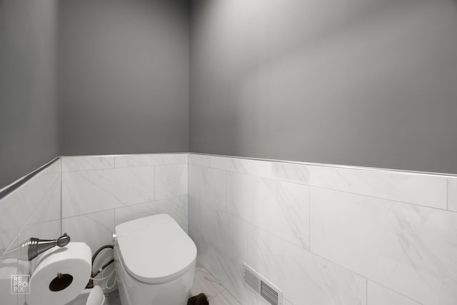 401 Jason Ln, Schaumburg, IL 60173 - half bathroom with toilet, visible vents, wainscoting, and tile walls