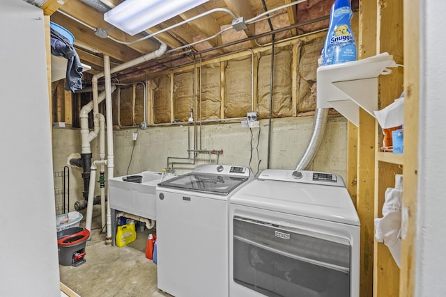 washroom with laundry area, washer and clothes dryer, and a sink