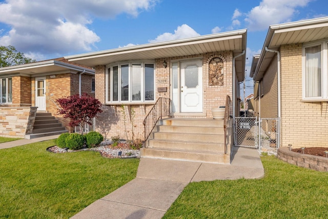 view of front of property with entry steps, a gate, brick siding, and a front yard
