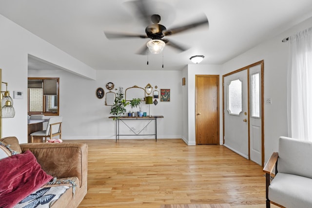 entrance foyer featuring baseboards, ceiling fan, a wealth of natural light, and light wood-style floors