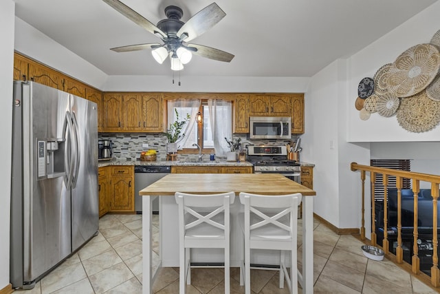 kitchen featuring backsplash, brown cabinets, and stainless steel appliances