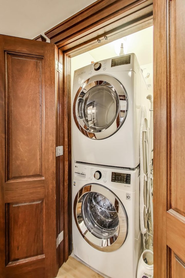 laundry room featuring stacked washer / drying machine and laundry area