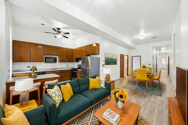living area featuring a ceiling fan and light wood finished floors