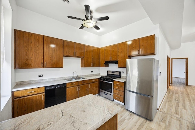 kitchen featuring brown cabinets, appliances with stainless steel finishes, a sink, a ceiling fan, and under cabinet range hood