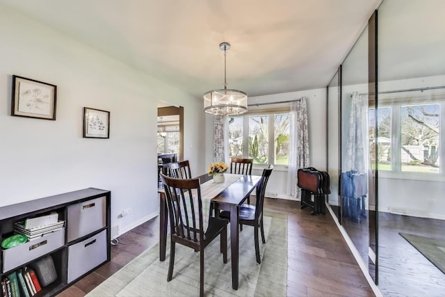 dining space with an inviting chandelier, wood finished floors, and a wealth of natural light