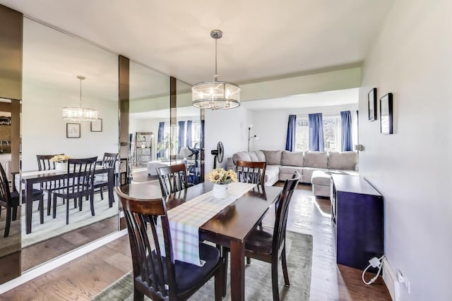 dining area featuring wood finished floors and a chandelier