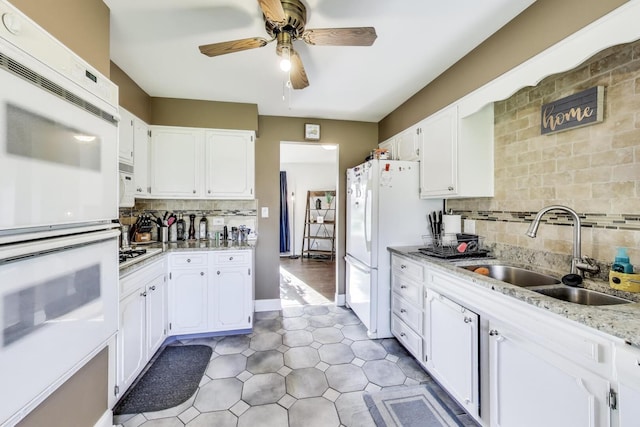 kitchen with ceiling fan, tasteful backsplash, a sink, white appliances, and white cabinetry