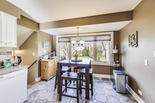 dining area featuring baseboards and a notable chandelier