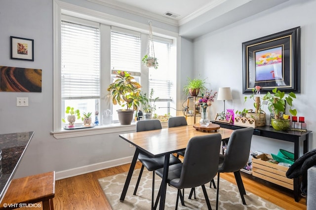 534 W Belmont Ave Unit 2S, Chicago, IL 60657 - dining space featuring crown molding, baseboards, light wood-style floors, and visible vents
