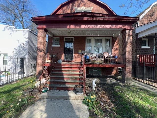 5705 S Wolcott Ave, Chicago, IL 60636 - view of front of house featuring covered porch, brick siding, and fence
