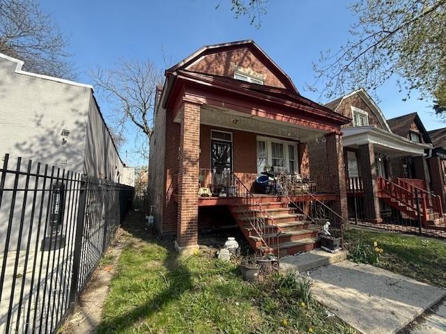 bungalow with fence private yard, a porch, stairway, and brick siding