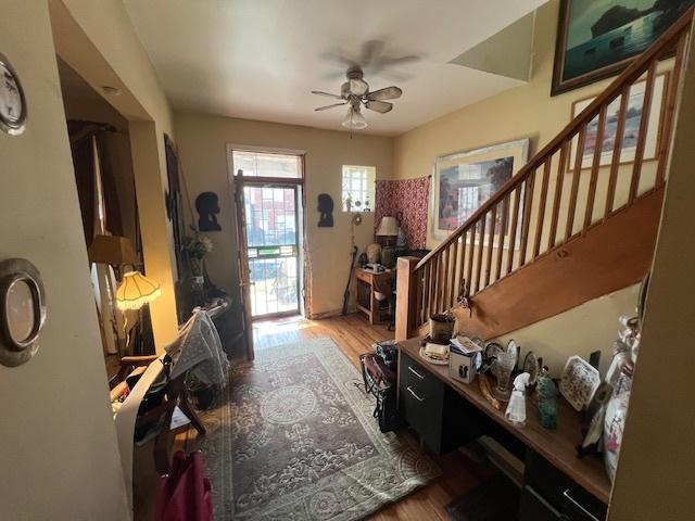 foyer featuring a ceiling fan, stairs, and wood finished floors