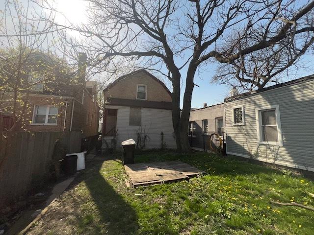 rear view of property with fence, a lawn, and a deck