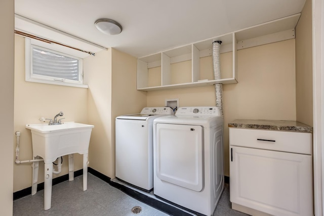 laundry area with baseboards, washer and clothes dryer, and light floors