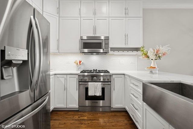 kitchen with white cabinets, stainless steel appliances, and ornamental molding