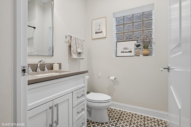 bathroom with baseboards, tile patterned floors, vanity, and toilet