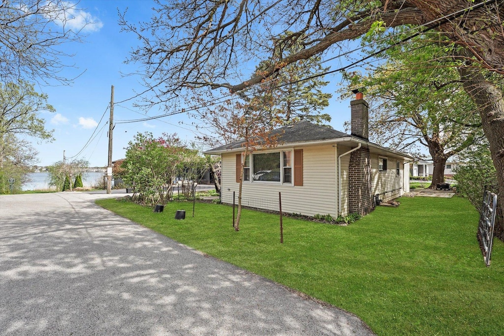 124 Roosevelt Ave, Wauconda, IL 60084 - view of front facade with a chimney and a front lawn
