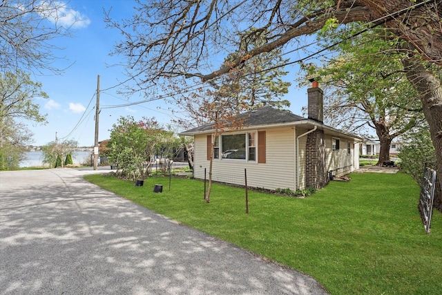124 Roosevelt Ave, Wauconda, IL 60084 - view of front facade with a chimney and a front lawn
