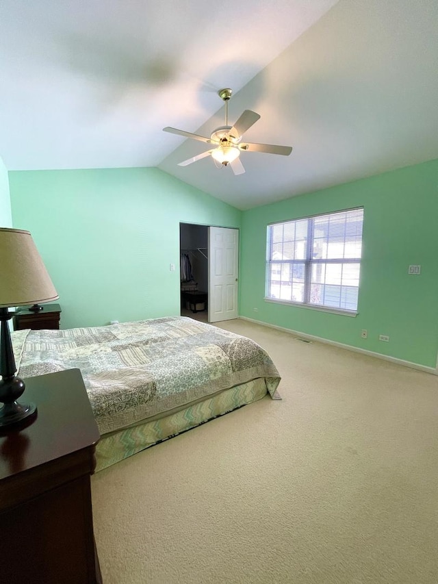bedroom featuring baseboards, light carpet, a closet, and lofted ceiling