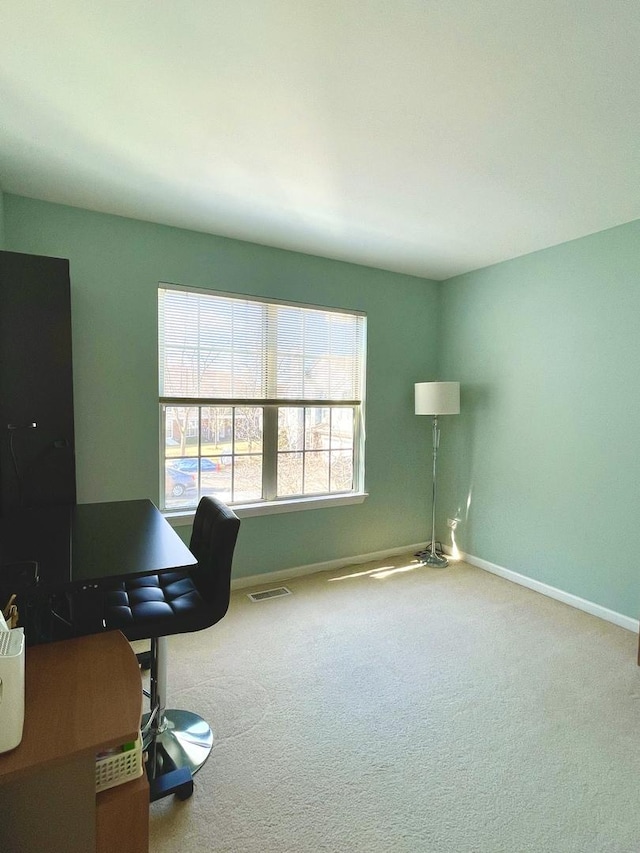 carpeted office space featuring baseboards and visible vents