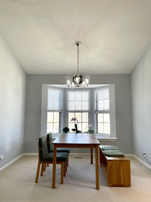 dining area featuring baseboards, a chandelier, light carpet, and visible vents