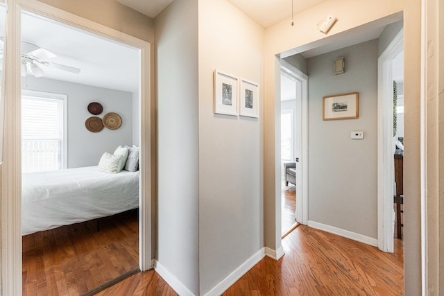 corridor featuring baseboards and wood finished floors