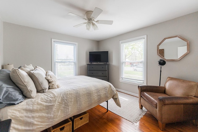 bedroom featuring baseboards, a ceiling fan, and wood finished floors