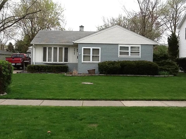 view of front of home featuring a chimney and a front yard