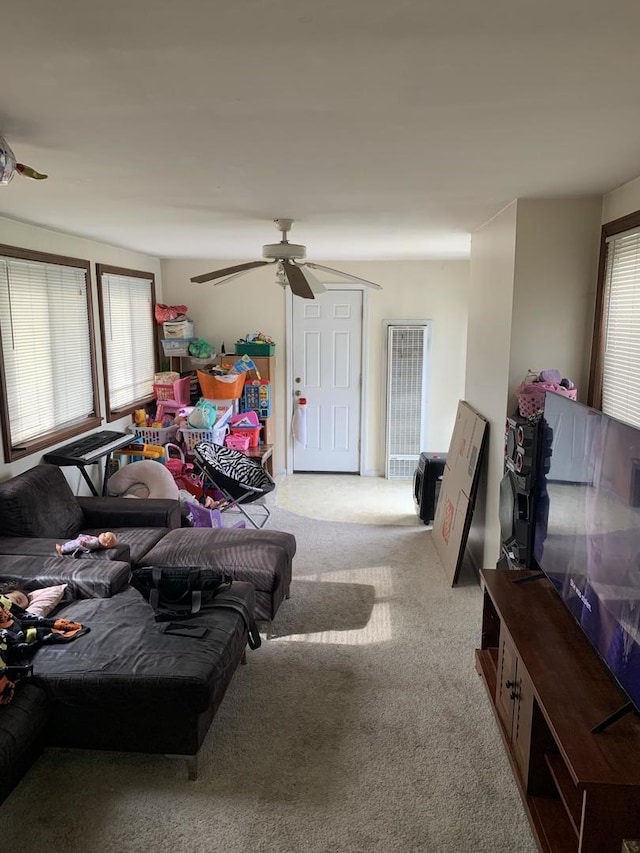 living room featuring a ceiling fan and carpet