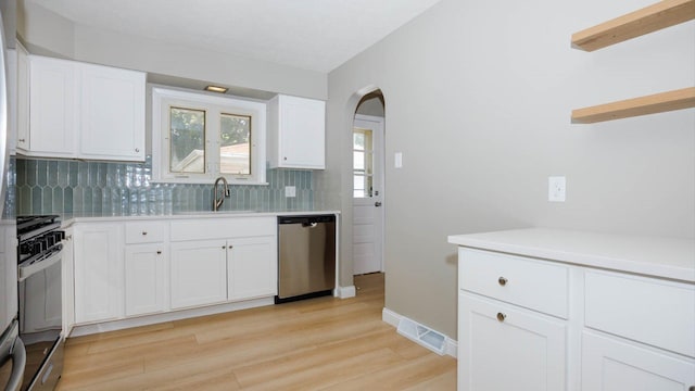 1201 S Mercer Ave, Bloomington, IL 61701 - kitchen featuring stainless steel dishwasher, range with gas cooktop, backsplash, light wood-style flooring, and light countertops