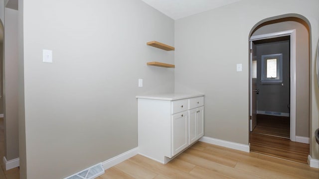 1201 S Mercer Ave, Bloomington, IL 61701 - corridor featuring arched walkways, light wood finished floors, and baseboards