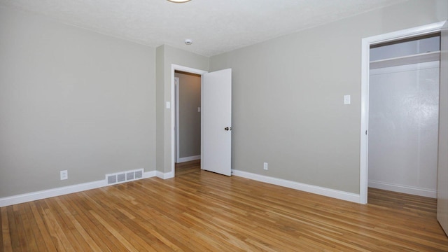 1201 S Mercer Ave, Bloomington, IL 61701 - unfurnished bedroom featuring light wood finished floors, baseboards, and a closet