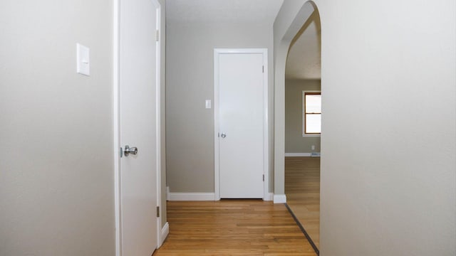 1201 S Mercer Ave, Bloomington, IL 61701 - hallway with arched walkways, light wood-style floors, and baseboards