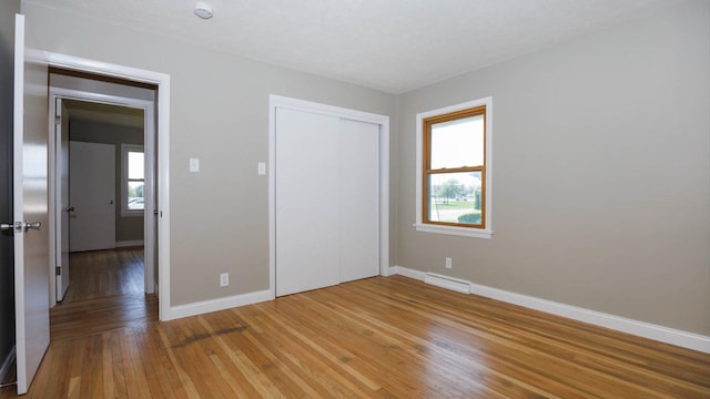 1201 S Mercer Ave, Bloomington, IL 61701 - unfurnished bedroom featuring multiple windows, baseboards, and light wood-style floors