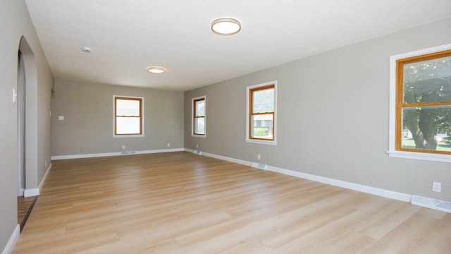 1201 S Mercer Ave, Bloomington, IL 61701 - empty room with light wood-style floors, baseboards, and arched walkways