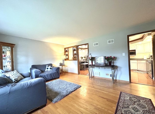 living area with light wood-type flooring and visible vents