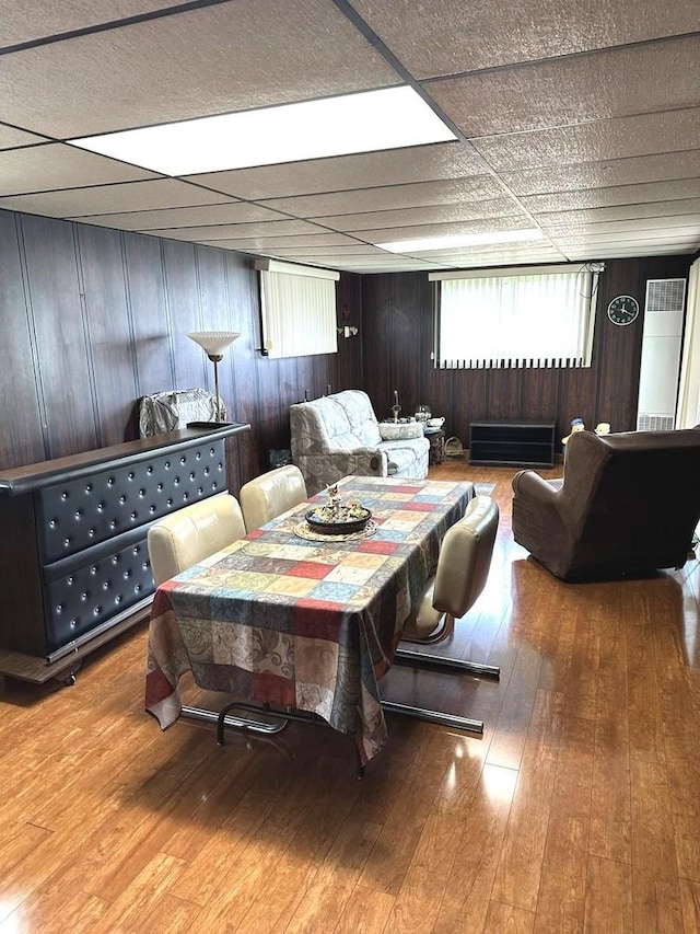 dining space featuring wooden walls and hardwood / wood-style floors