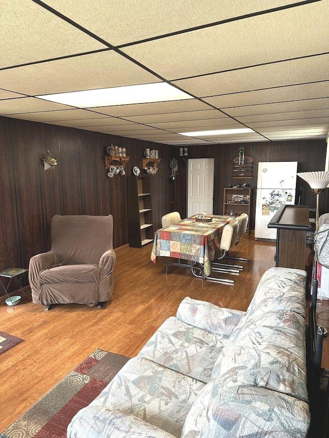 living area with wood finished floors and wooden walls